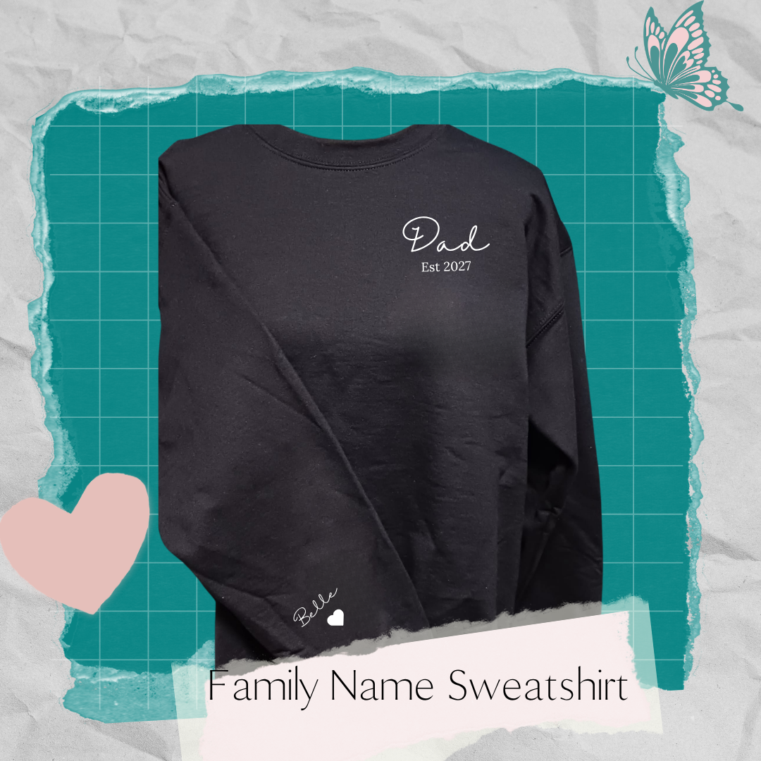 Black sweatshirt with white “Dad Est 2027” on the front left chest and “Bella” with a heart on the right sleeve.